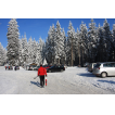 Die Straße und der Parkplatz werden zu Fuß überquert.